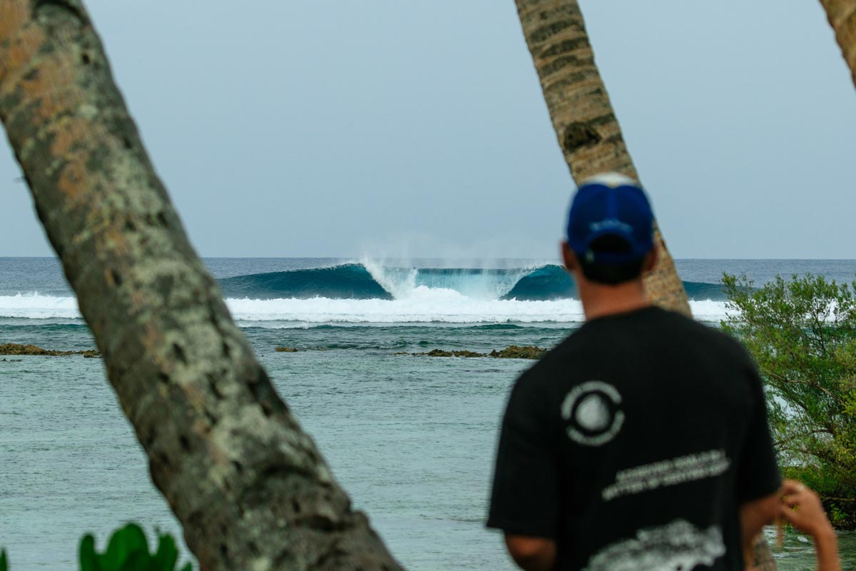 Una persona observa las olas de Cloud 9 entre las palmeras de Siargao, Filipinas