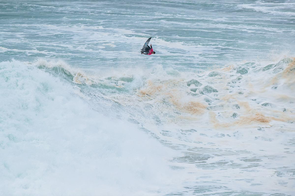 Surfista de tow-in enfrentándose a una ola gigante durante un día de marejada en Nazaré.