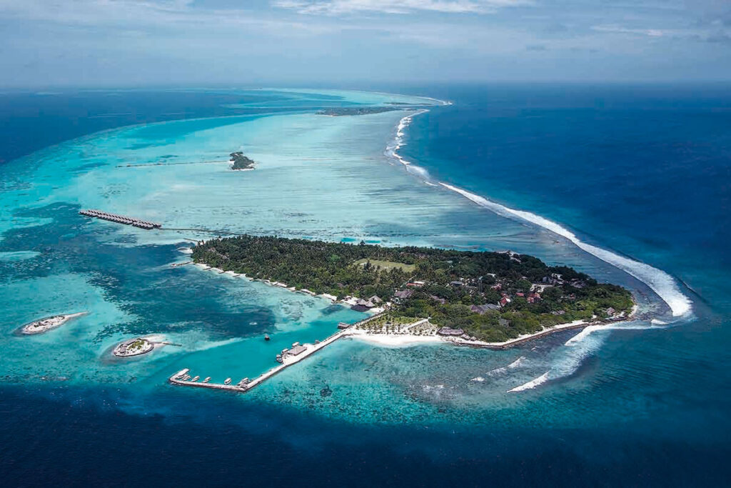 Viajes de surf en Maldivas para familias en una isla rodeada de olas y aguas turquesas