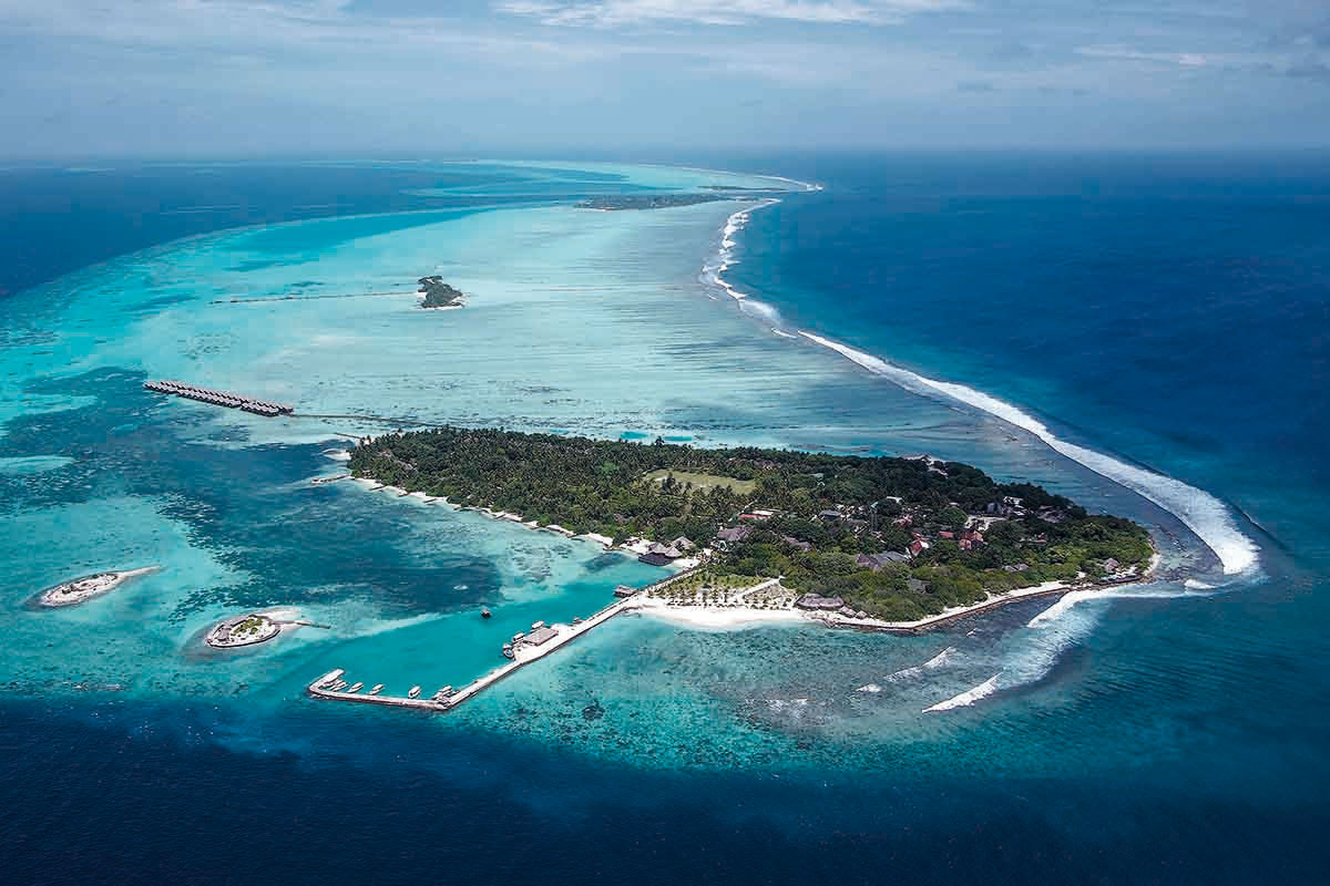 Viajes de surf en Maldivas para familias en una isla rodeada de olas y aguas turquesas